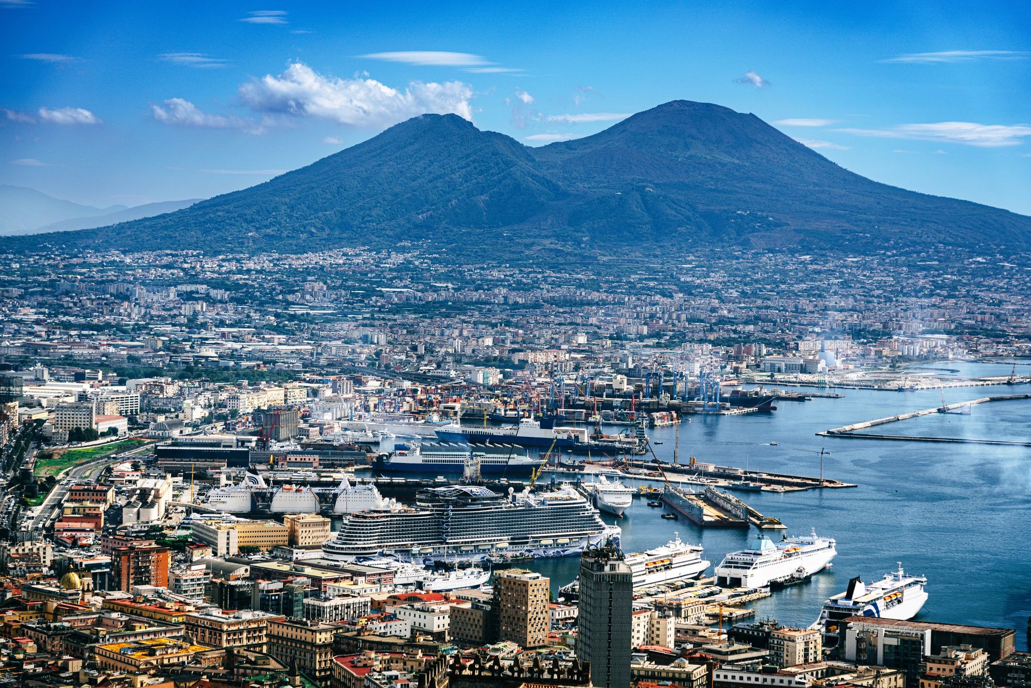 Bright aerial view of Naples harbor and Vesuvius